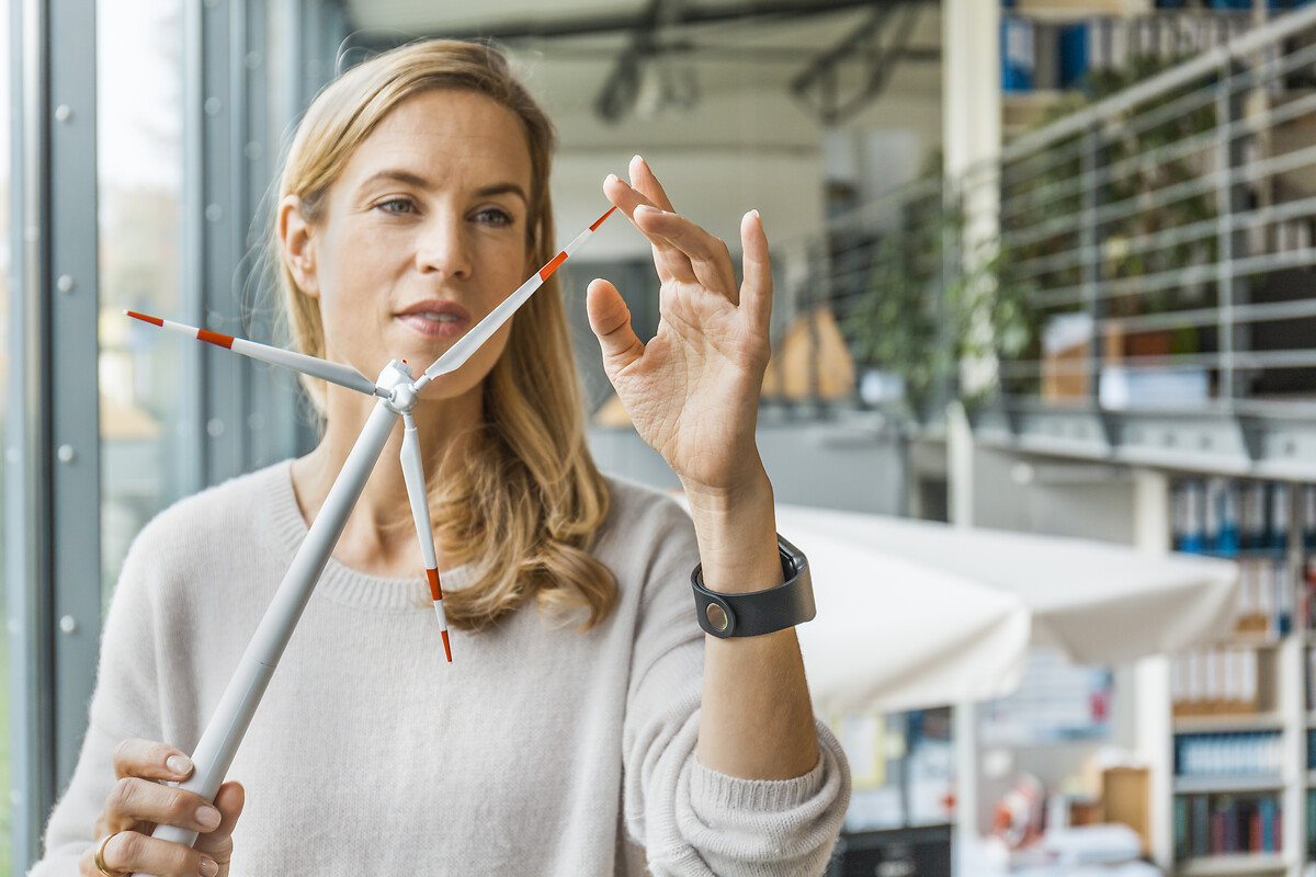  Femme au bureau travaillant sur une maquette d'éolienne