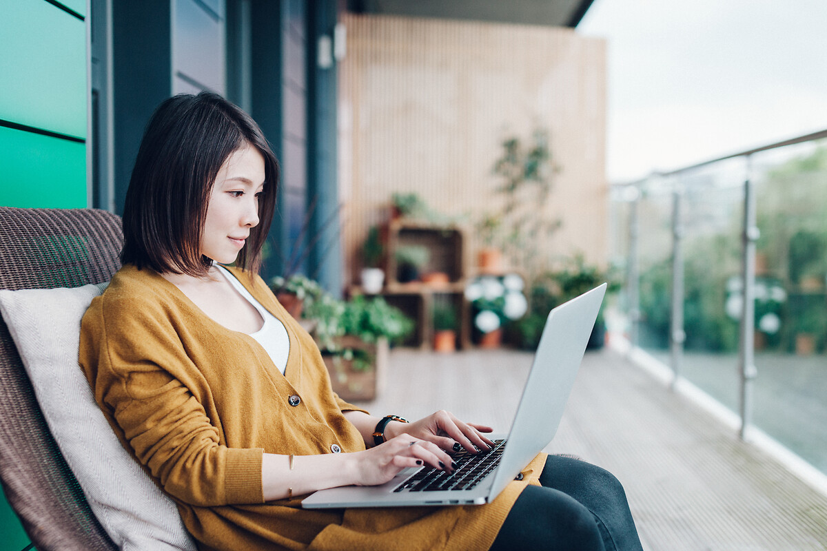 Femme d'affaires utilisant un ordinateur portable sur un balcon