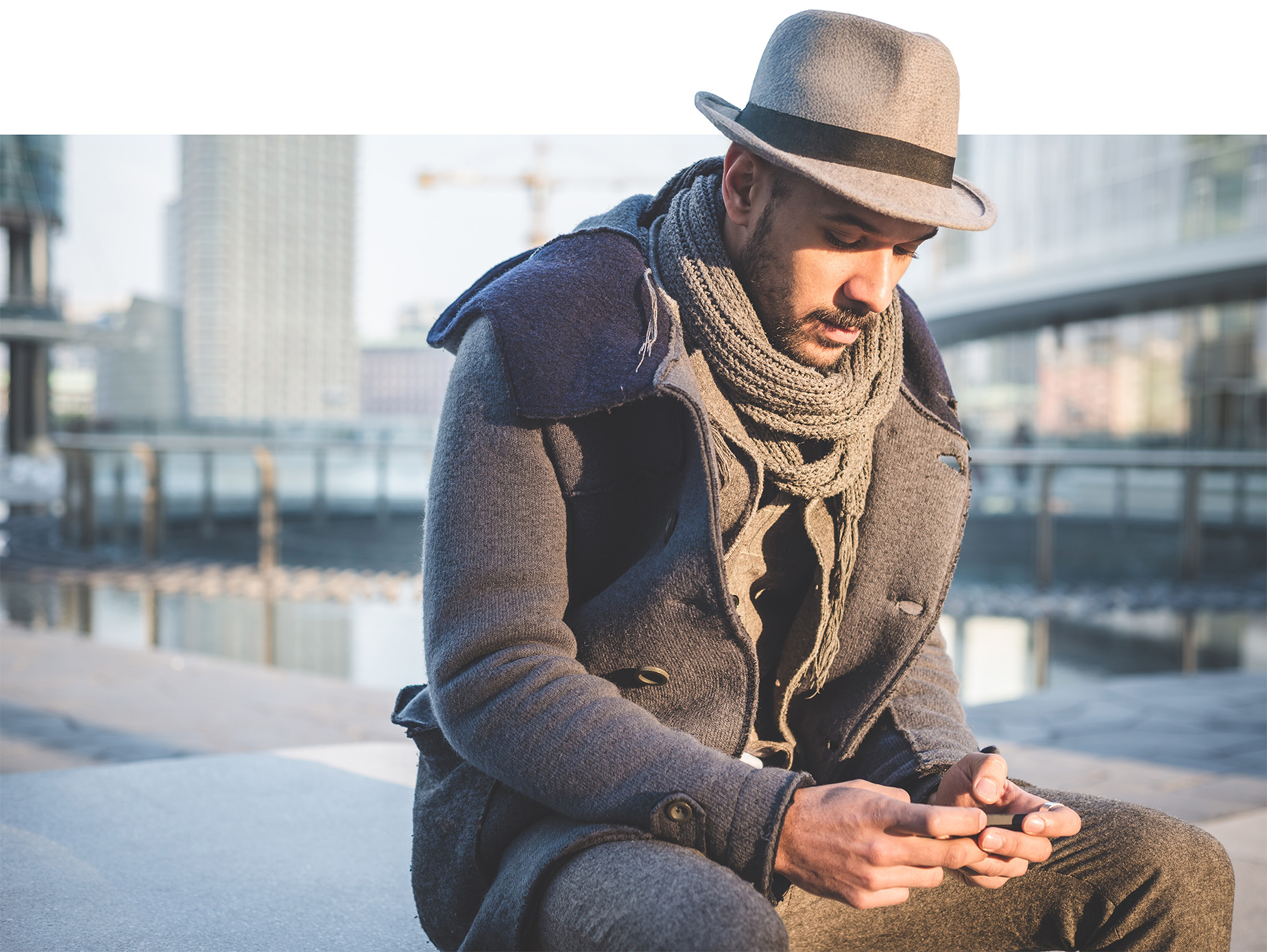 Photo d'un homme assis en train de regarder son téléphone