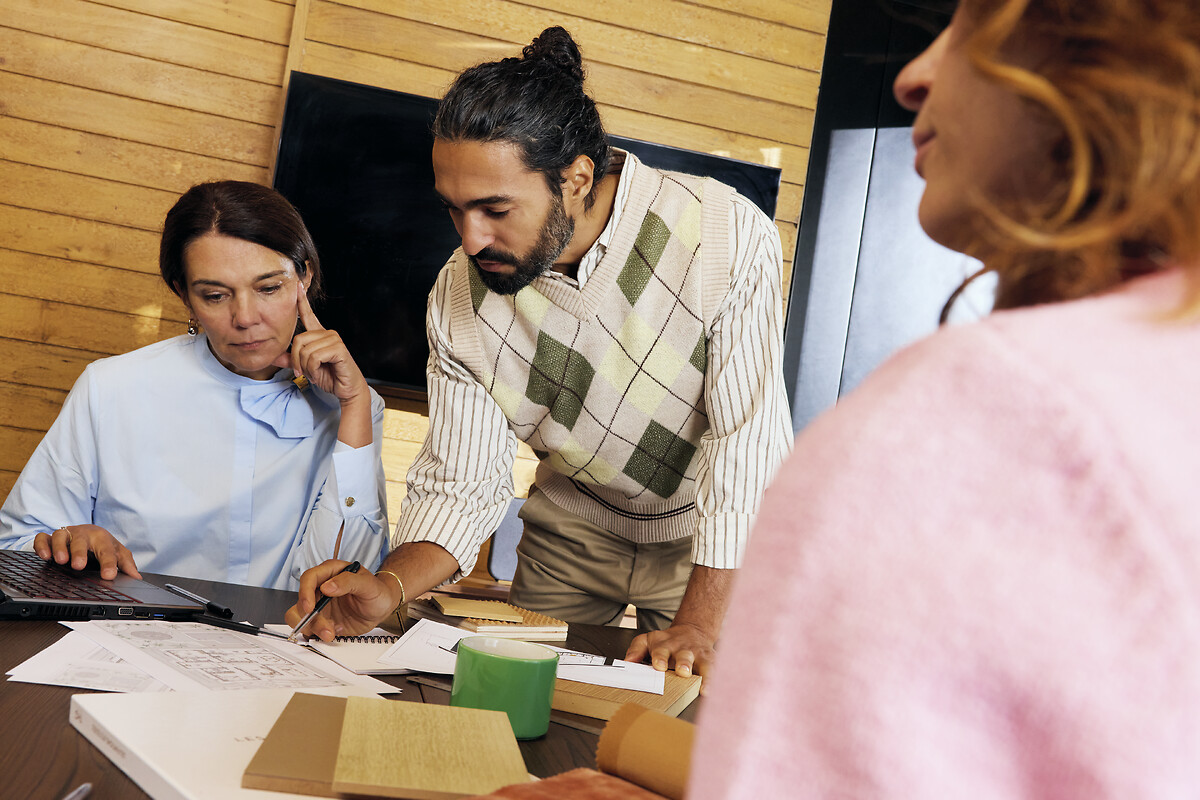 Un homme en pleine explication aux coté d'une femme devant son ordinateur 