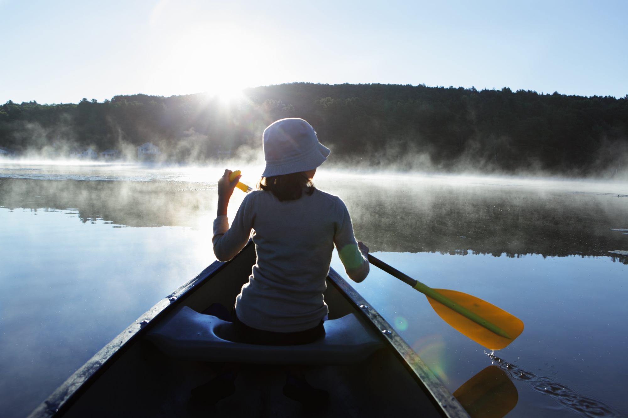 Femme de dos sur un canoé en train de ramer