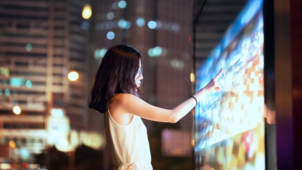 Femme touchant un écran dans la rue