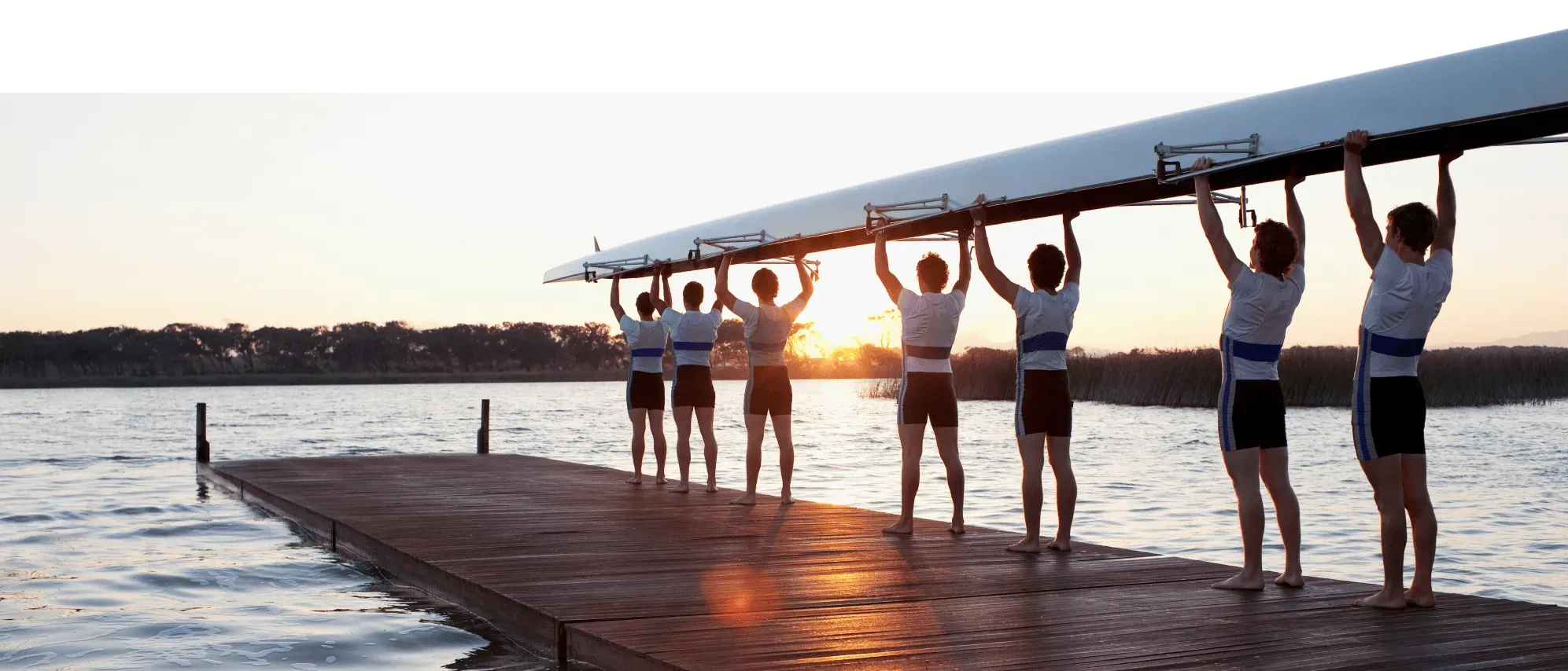 Une équipe d'aviron tenant un bateau au-dessus de sa tête