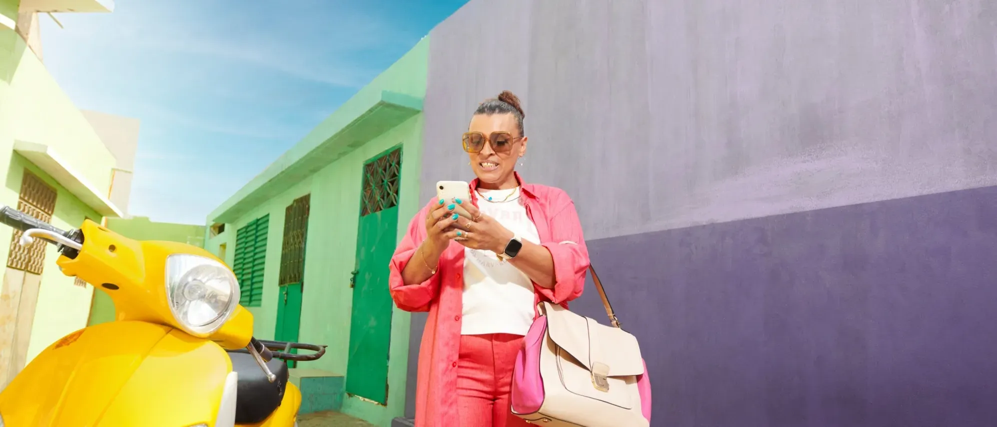 Femme souriante marchant avec un téléphone dans les mains