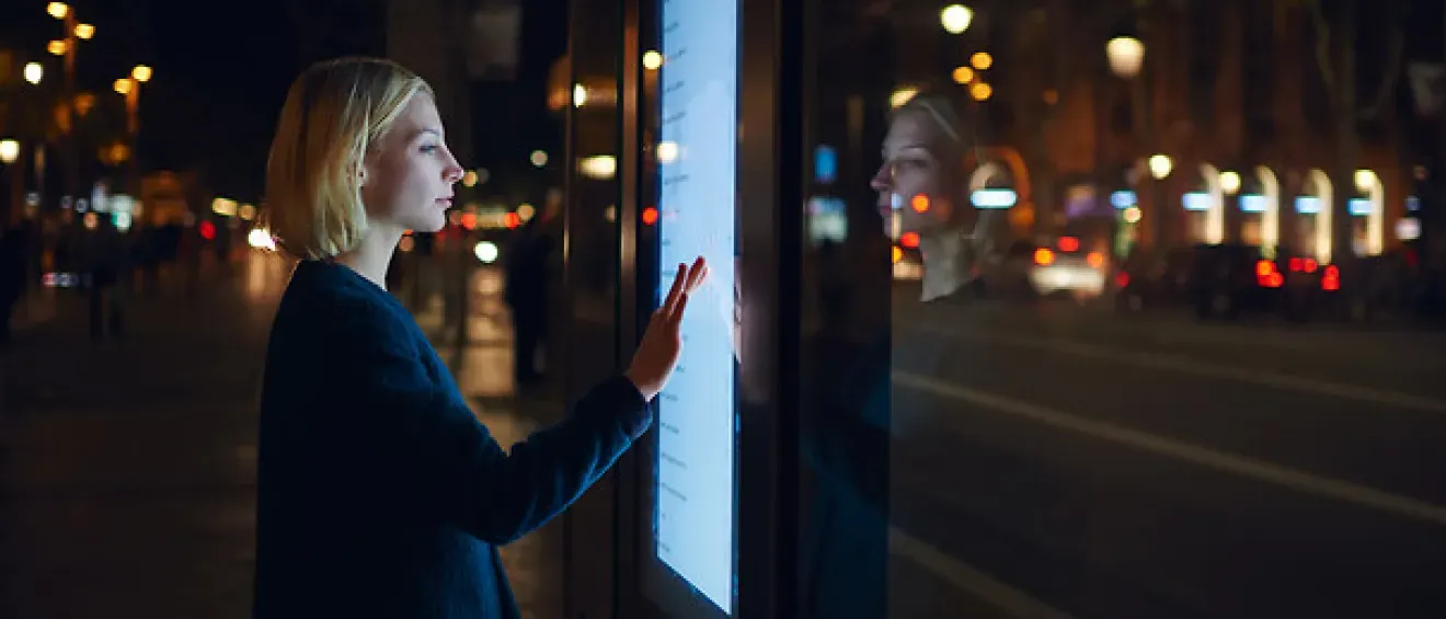 Femme devant un écran digital à l'extérieur