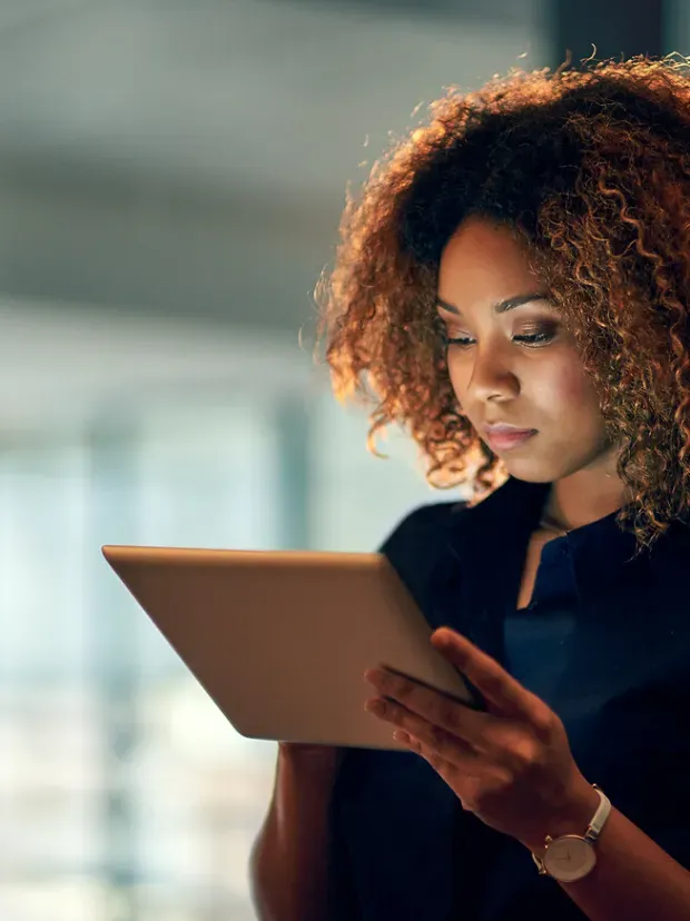 Femme dans des bureaux en train de regarder une tablette