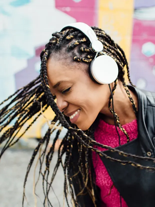 Une jeune femme secoue la tête en écoutant de la musique