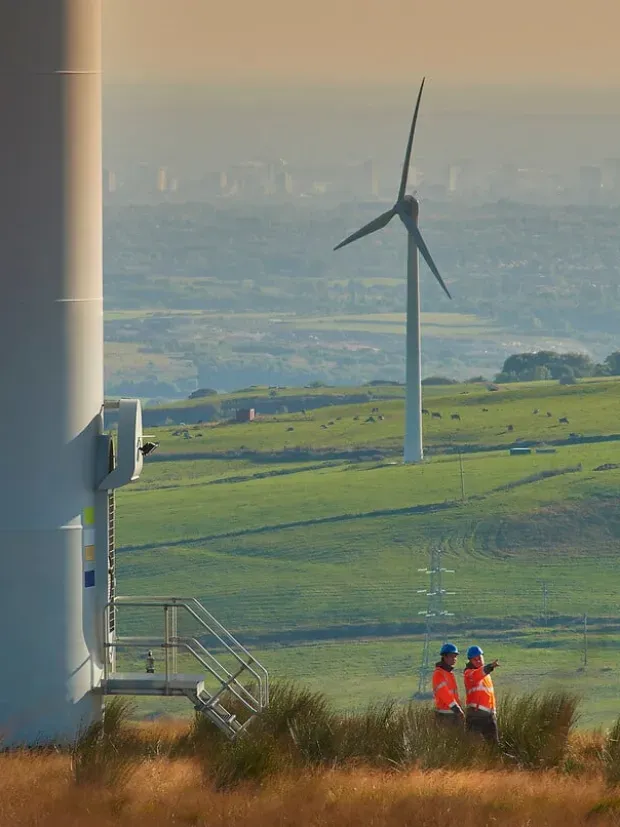 deux techniciens dans un champs d'éoliennes
