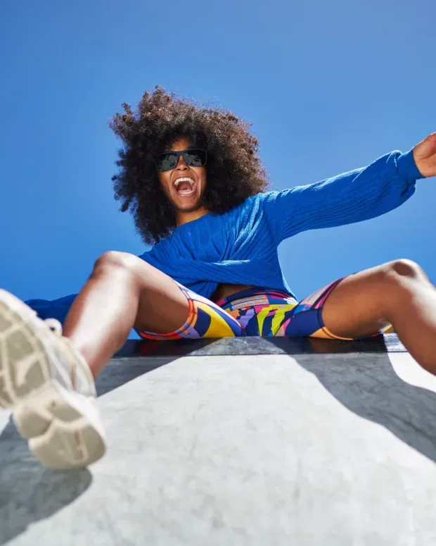 Jeune femme posant sur un mur à l'extérieur