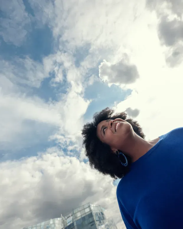 Femme en contre-plongée avec le ciel en fond
