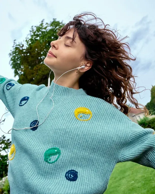  Une jeune fille danse avec des écouteurs.