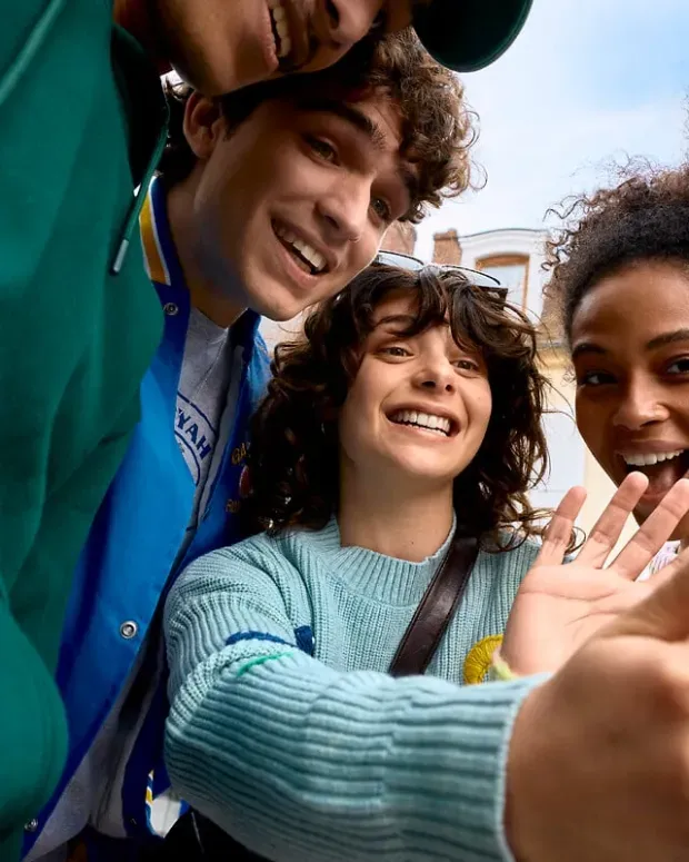Un groupe de jeunes devant un écran de téléphone portable.