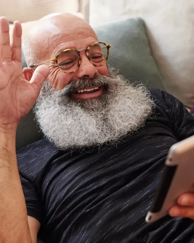Vieil homme allongé avec une tablette