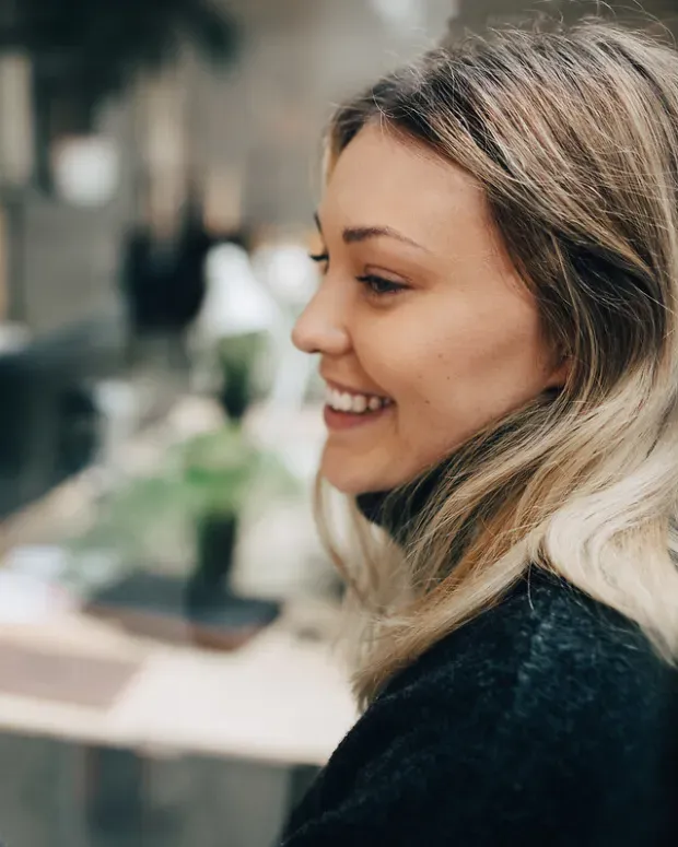  Une femme souriante colle des Post-it sur une vitre
