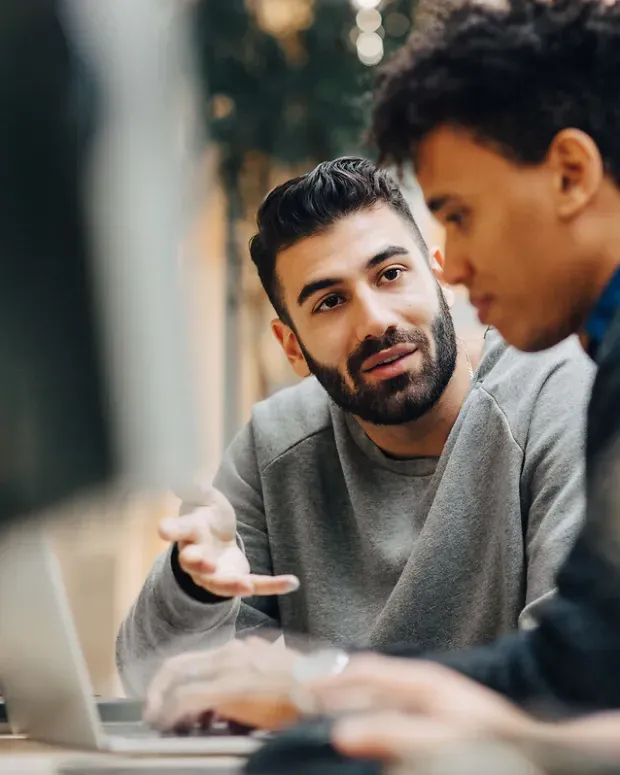 Des collègues discutent devant un ordinateur