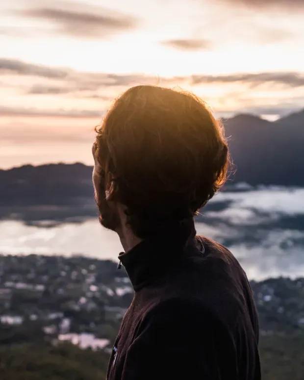 Homme de dos regardant un paysage en bord de mer