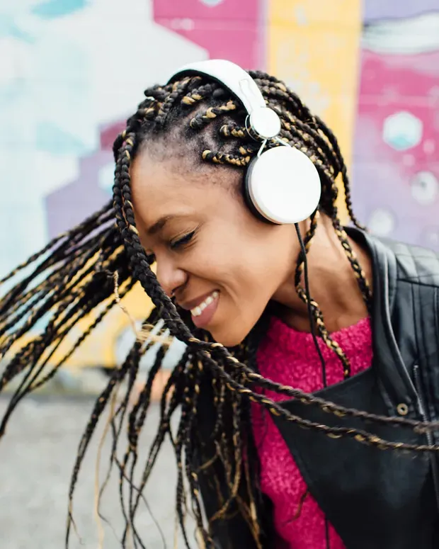 Une jeune femme secoue la tête en écoutant de la musique