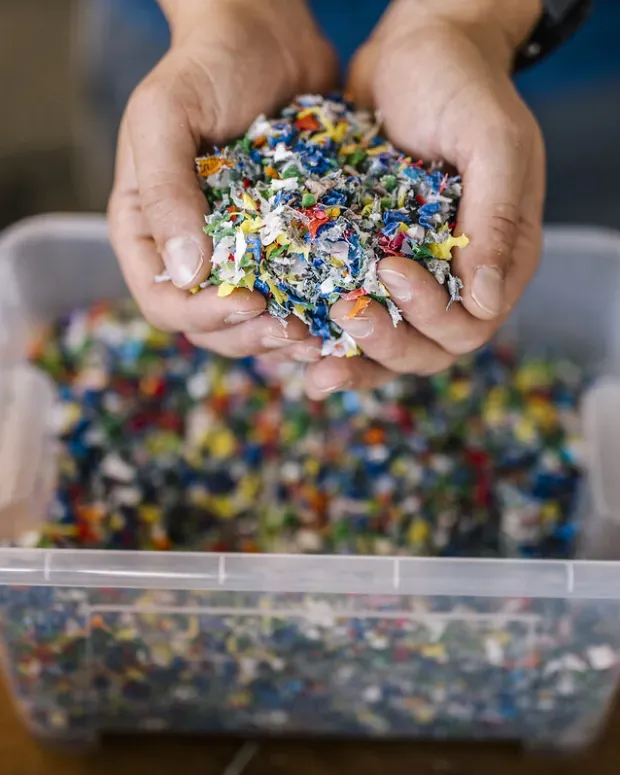 mains qui brasse dans un bac de recyclage  