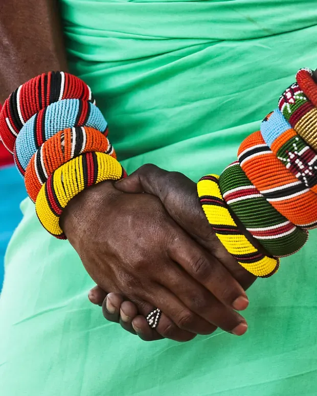 Gros plan sur les bras d'une femme portant des bracelets colorés en perles, bijoux traditionnels africains.