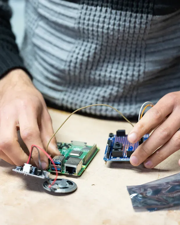 Mains d'un homme réparant un appareil électronique