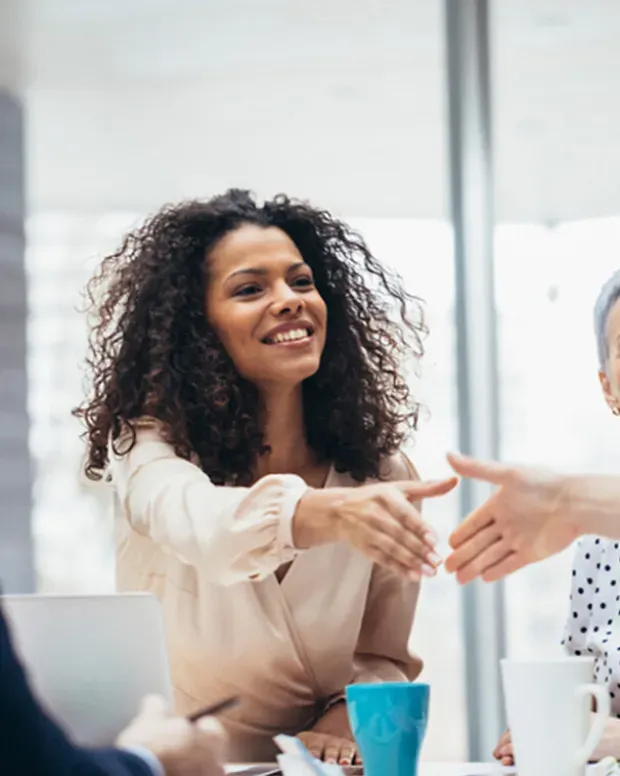 Une femme sert une main pendant une réunion