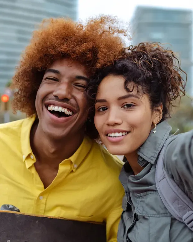 Jeune couple en extérieur, souriant