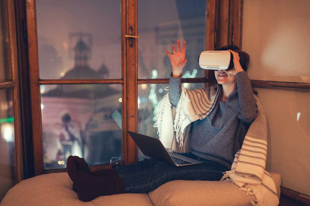 Photo d'une femme dans son salon avec un casque de réalité virtuelle