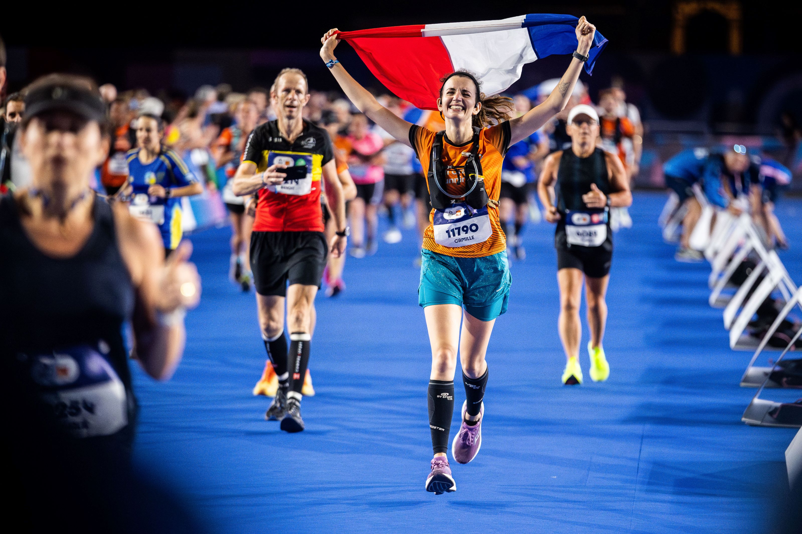 photo of a marathon runner waving the French flag