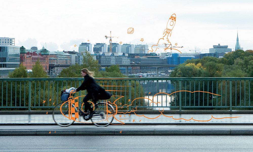 Photo d'une femme faisant du vélo sur un pont, il y a des illustrations sur la photo comme par exemple une fusée et des planètes