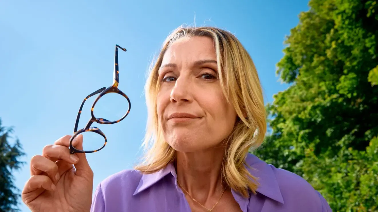 une femme au regard suspicieux regarde l'objectif