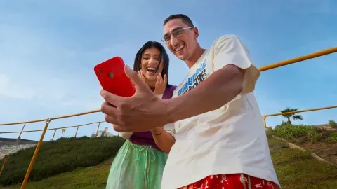 Deux jeunes subshahariens tenant un téléphone en souriant