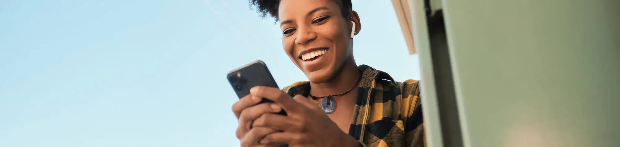 Femme souriante regardant son téléphone