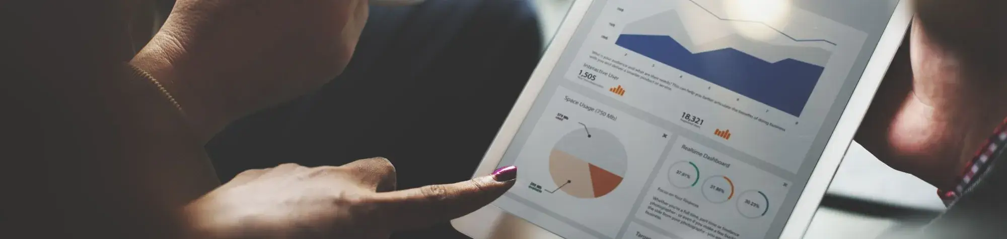 Photo d'une personne tenant un ipad avec des graphiques en hausse