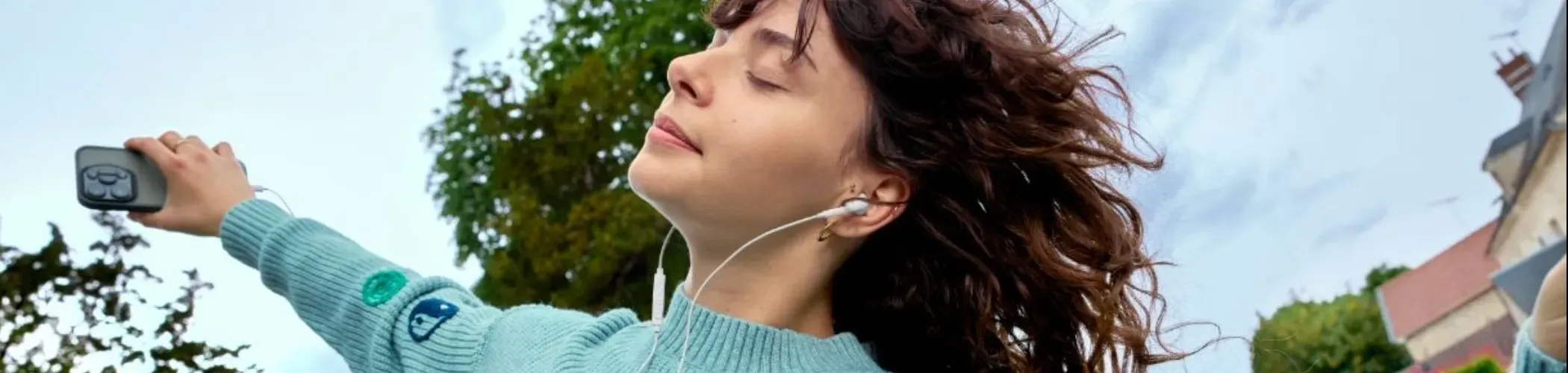 Une jeune fille danse avec un casque audio sur les oreilles