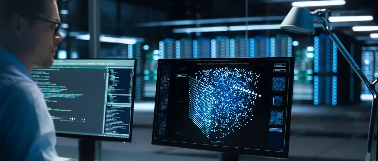 un homme se tennat devant des écrans d'ordinateur