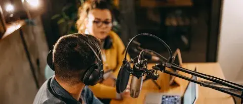 Studio radio un homme et une femme discutent avec un casque et un micro