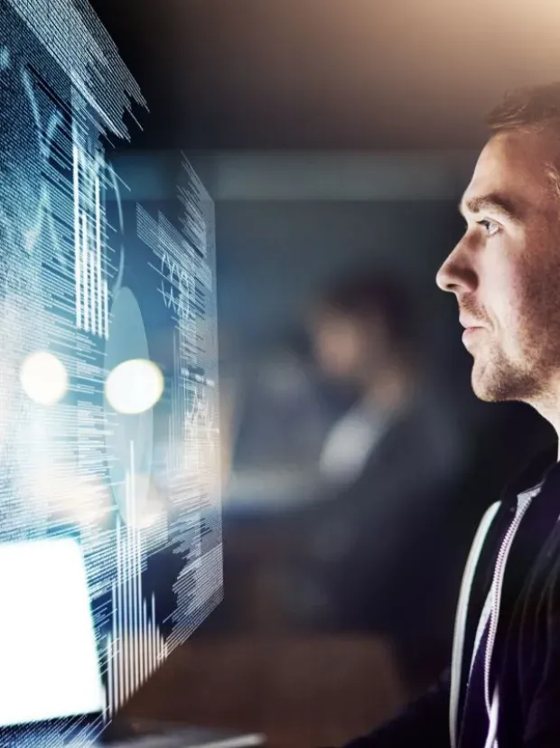 homme devant séries d'écrans d'ordinateurs