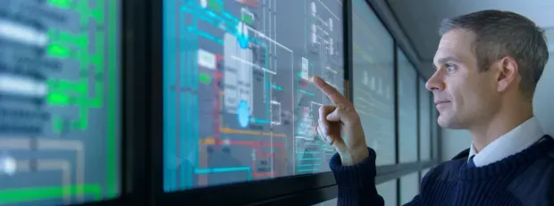 Homme regardant des données sur des écrans tactiles