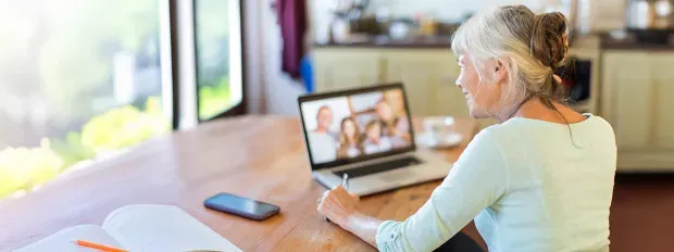Une dame consultant son ordinateur au sein de son foyer