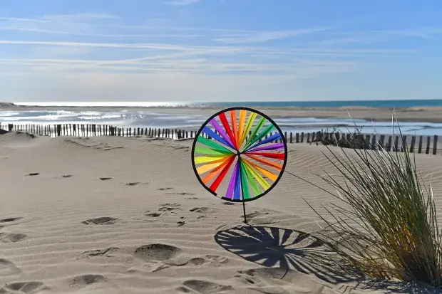 Un jouet éolienne planté sur la plage